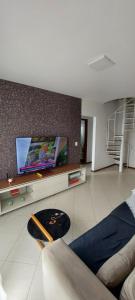 a living room with a flat screen tv on a wall at Quarto in Vila Velha