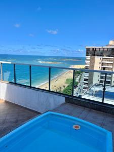 a bath tub on a balcony with a view of the beach at Quarto in Vila Velha
