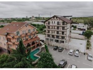 a building with cars parked in a parking lot at Apartamente9 Aurelia baile felix in Baile Felix
