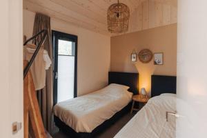 una camera da letto con due letti e una finestra di Kos I Tiny house met grote tuin a Epe
