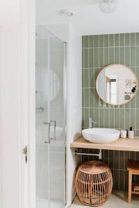 a bathroom with a sink and a glass shower at Kos I Tiny house met grote tuin in Epe