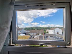 a window with a view of a city at Cosy 3-Bed House in Kidwelly in Kidwelly