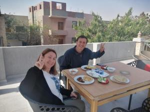 a man and a woman sitting at a table with food at lsis pyramids view in Cairo