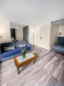 een woonkamer met een blauwe bank en een salontafel bij Chic Parisien en Cœur de Ville in Parijs