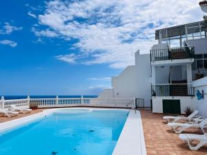 einem Pool an der Seite eines Gebäudes in der Unterkunft Corona Amarilla Sea View and Relax Puerto Rico in Puerto Rico de Gran Canaria