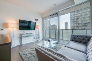 un soggiorno con divano e TV a schermo piatto di 1BR Condo - City View, Near CN Tower & Rogers Center a Toronto