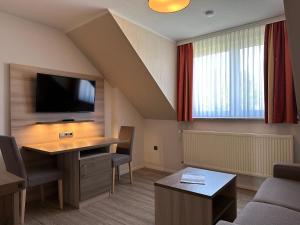 um quarto com uma secretária e uma televisão de ecrã plano em Appartementanlage Zur Seemöwe em Insel Poel