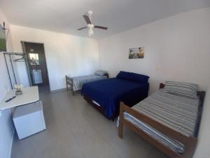 1 dormitorio con 2 camas y ventilador de techo en POUSADA SÃO LUCAS, en Águas de Lindóia
