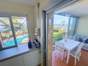 a dining room with a table and a view of the ocean at Vue baie à 5min de la plage 44m² avec parking in Théoule-sur-Mer