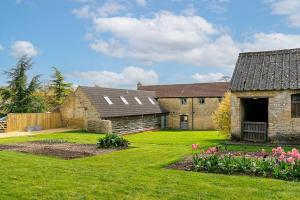 an old stone building with a yard with flowers at Glyme Flat - Peaceful Country Retreat! in Chipping Norton