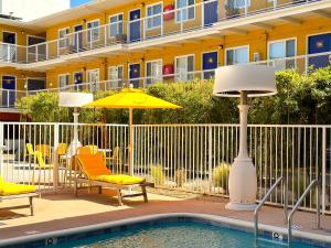 a pool with chairs and an umbrella and a building at Hotel Del Sol in San Francisco
