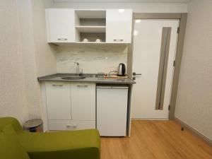 una pequeña cocina con fregadero y un sofá verde en gazelle suites, en Estambul