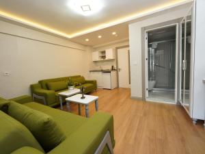 sala de estar con sofá verde y mesa en gazelle suites, en Estambul