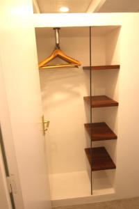 a closet with wooden shelves and a door at Studio Kaza Blanka - Saint Leu - Réunion in Saint-Leu
