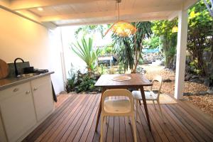 a patio with a table and chairs on a deck at Studio Kaza Blanka - Saint Leu - Réunion in Saint-Leu