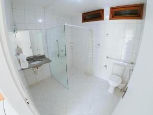 uma casa de banho com uma cabina de duche em vidro e um WC. em Hotel Arrastão em São Sebastião