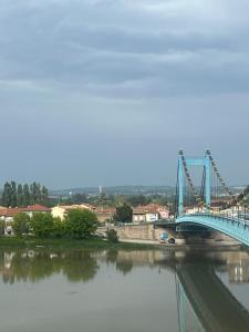 un puente azul sobre un río con reflejos en el agua en Appartement privé « Blue Bridge & Sauna », en Serrières