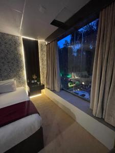 a bedroom with a bed and a large window at The Life Style Lodges opp Centaurus Mall in Islamabad