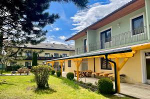 a building with a patio with tables and chairs at Pension Miklautz in Sankt Kanzian