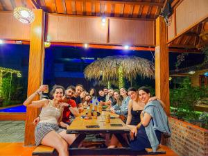 grupa ludzi siedzących przy stole w restauracji w obiekcie Trang An Village Homestay w mieście Ninh Binh