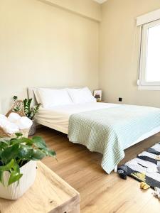 1 dormitorio con 1 cama con manta verde y blanca en 2 Doors, en Kavala