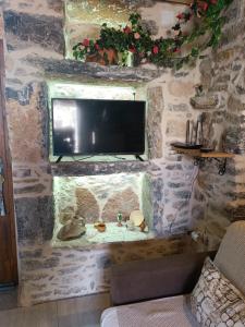 pared de piedra con TV en una habitación en ΜΕΣΤΑ - ΠΛΑΤΕΙΑ en Mestá