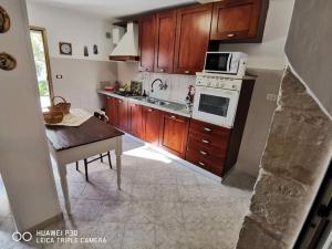 uma cozinha com armários de madeira e um forno de fogão branco em Casa Vittoria em Vignacastrisi