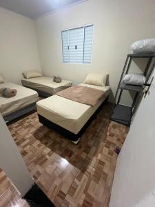 1 Schlafzimmer mit 2 Betten und Holzboden in der Unterkunft Casa do Monte in Guarulhos