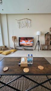 a living room with a television and two water bottles at Wonderful two bed room with full marina view in Dubai