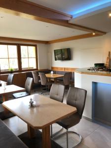 a restaurant with tables and chairs and a kitchen at Hotel Ötscherblick in Lackenhof