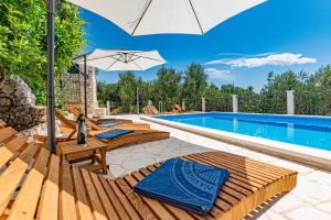 una piscina con sedie e ombrellone accanto a una piscina di Betelgeuse a Jesenice