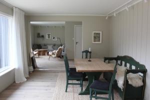 a dining room with a wooden table and chairs at Solstad fritidsbolig in Hjelle