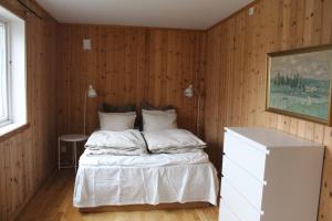 a bedroom with a bed in a wooden wall at Solstad fritidsbolig in Hjelle