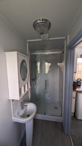 a bathroom with a glass shower and a sink at Lynstone Lakes in Bude +66 photos