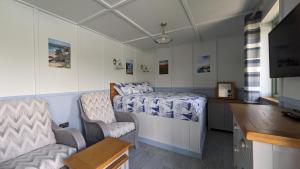 a small room with a bed and a chair at Lynstone Lakes in Bude