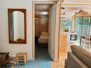 a living room with a couch and a mirror at Jasmine House in Amirim