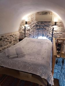 ein Schlafzimmer mit einem Bett mit einer weißen Bettdecke in der Unterkunft ΜΕΣΤΑ - ΠΛΑΤΕΙΑ in Mestá