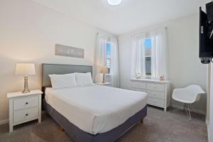 um quarto branco com uma cama grande e 2 janelas em Pool Villa wFREE Resort Access Great Reviews em Kissimmee
