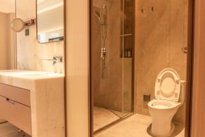 a bathroom with a shower and a toilet and a sink at Guus Hotel in Zengcheng