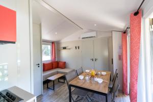 - une salle à manger avec une table et un canapé dans l'établissement Camping Le Damier, à Pianottoli-Caldarello
