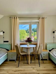 a bedroom with a table and chairs and a window at Apartament Przy Parku in Muszyna