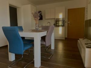 a kitchen with a white table and blue chairs at Blueberry in Bol