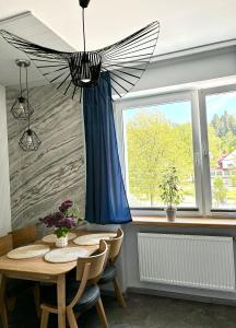 a dining room with a table with a blue curtain at Apartament Przy Parku in Muszyna