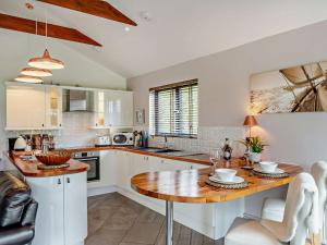 a kitchen with a wooden table and white cabinets at 1 Bed in Nether Stowey 36190 in Nether Stowey