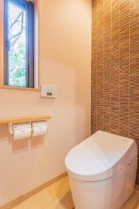 a bathroom with a white toilet and a window at Oukai Villa Izumi in Izumi