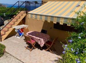 einen Tisch und Stühle auf einer Terrasse neben einem Haus in der Unterkunft Monolocale “La Panoramica” in Rio Marina