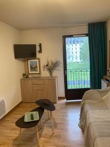 a room with a bed and a tv and a window at Appartement T2 Jardins de Ramel in Luchon