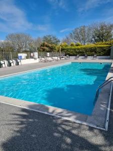 ein Schwimmbad mit blauem Wasser in einem Ferienort in der Unterkunft Cosy 2 bed pet friendly holiday home Crantock Nr Newquay in Crantock
