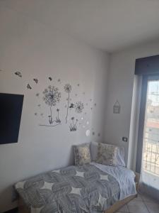 Schlafzimmer mit einem Bett mit Löwenzahn an der Wand in der Unterkunft Iris in Cislago