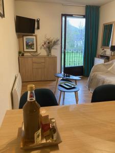 um quarto de hotel com uma garrafa na mesa em Appartement T2 Jardins de Ramel em Luchon